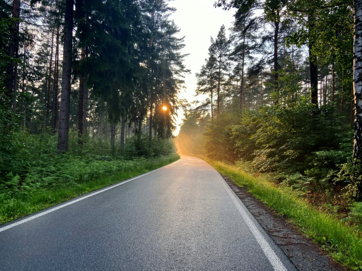 a road with a person driving a bike on it through the middle of the road