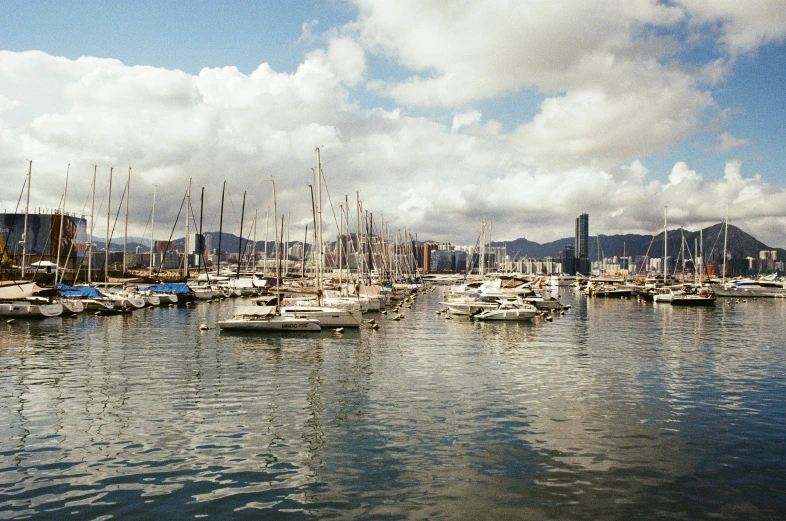 a harbor filled with lots of boats in front of mountains