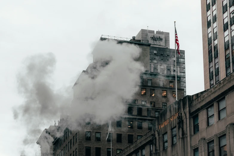 steam rises from the tops of buildings on a city street