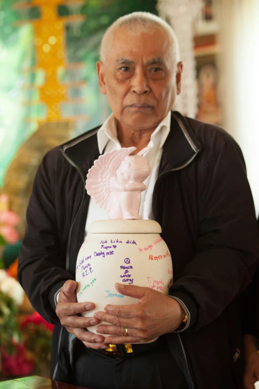 a man holding a jar filled with writing on it