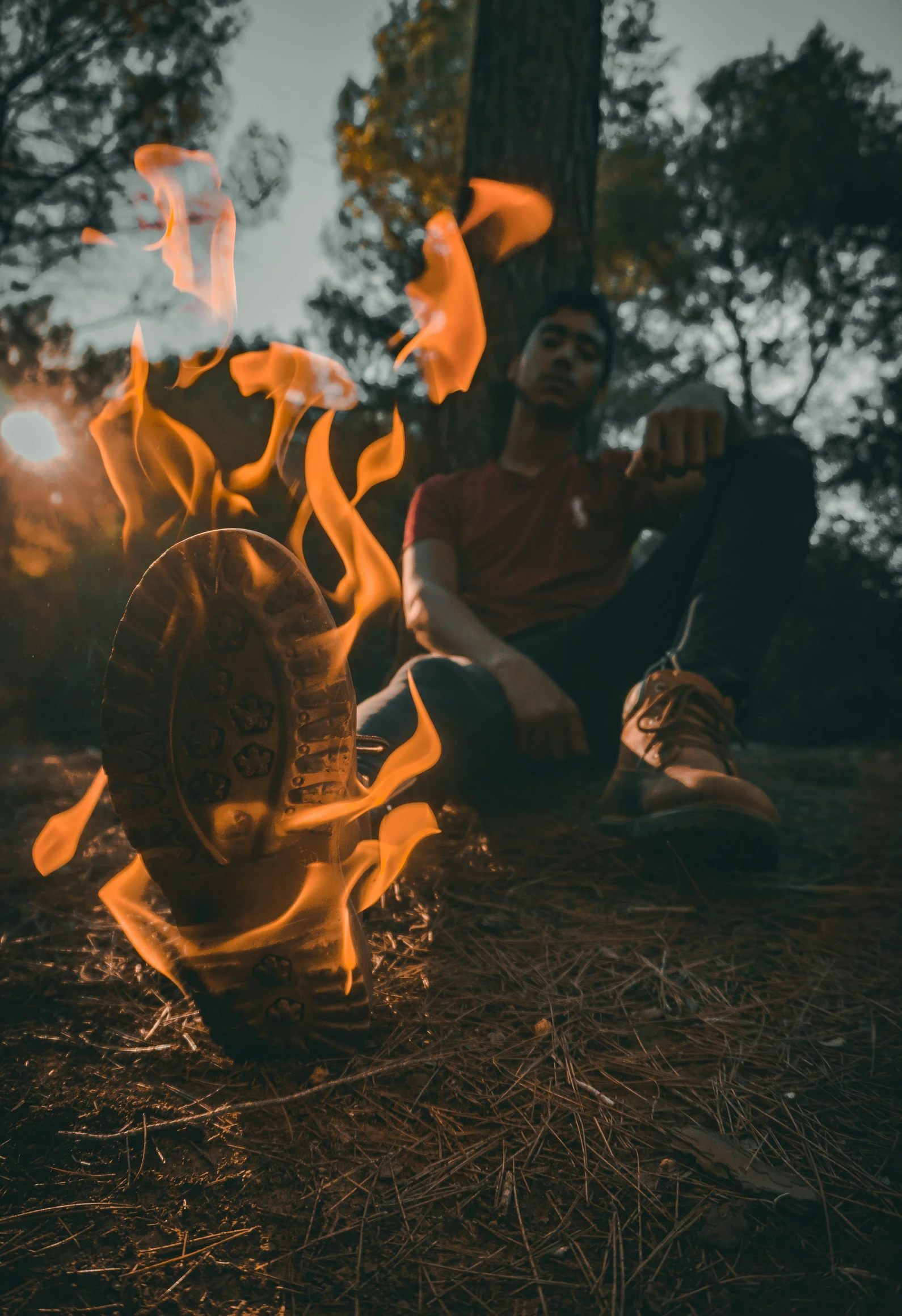 a person sitting on a ground next to a fire