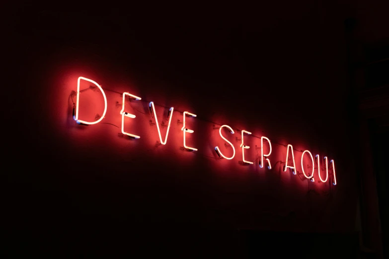 neon sign of deve seraou on the wall