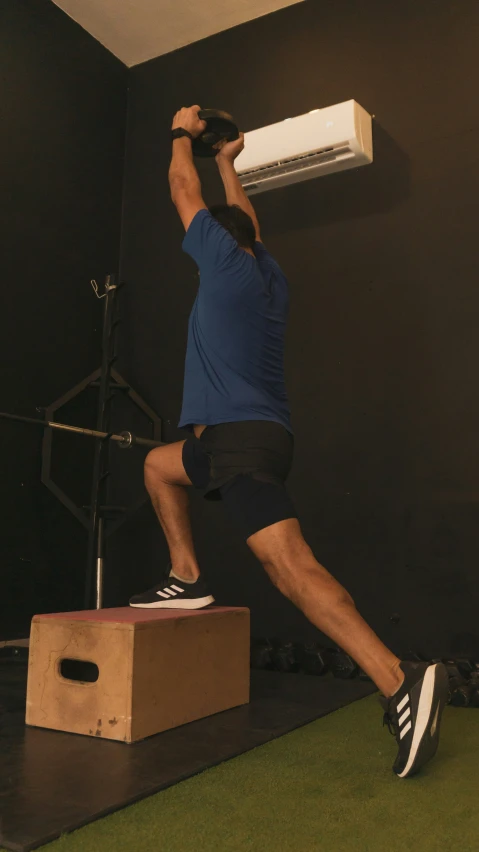 a man performing a jump on a chair in a gym