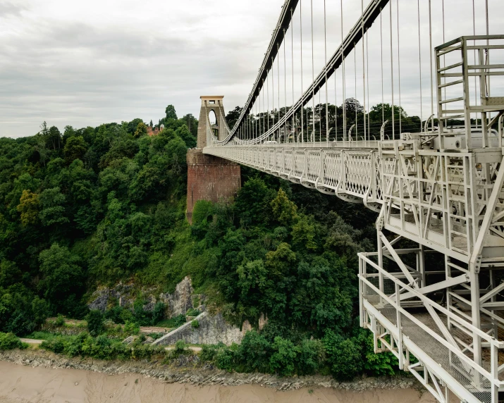 a very big bridge spanning a river by a cliff