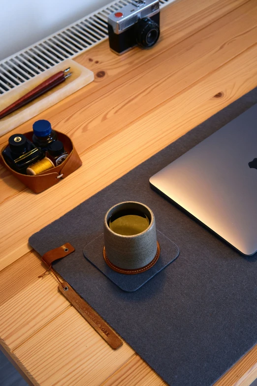 a cup of coffee is near an apple laptop on a table