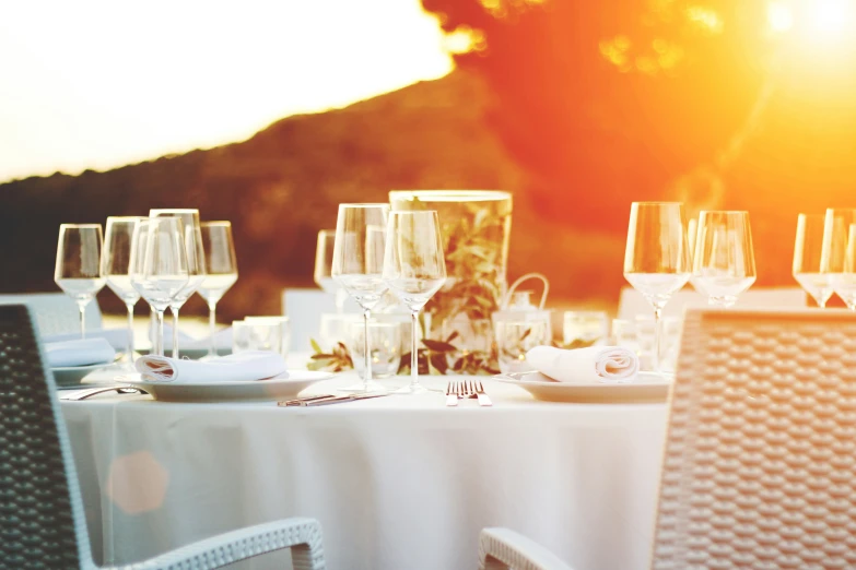 wine glasses and plates on a table with white cloths