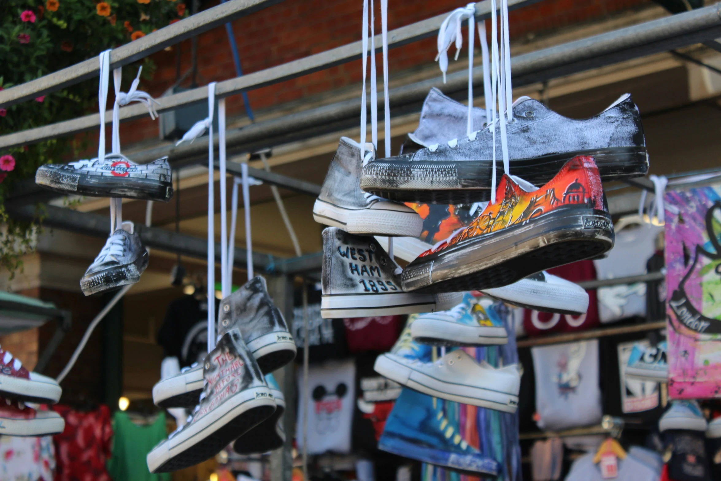 sneakers and t shirts are hanging from hooks