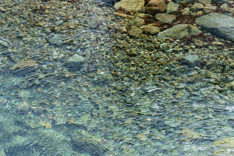 the view of water from above, with rocks on the ground