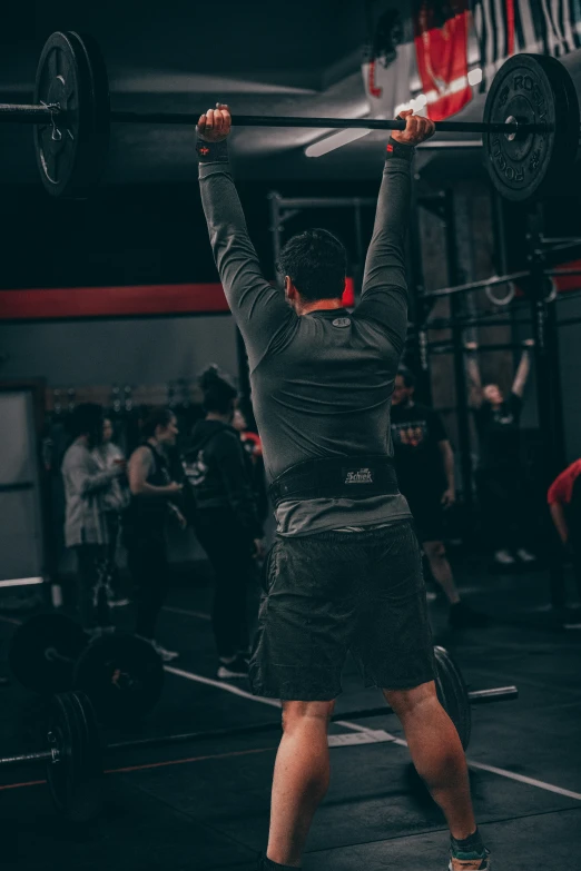 a man in a gym is lifting heavy bars