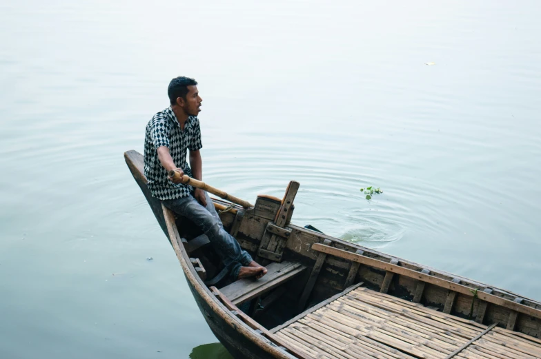 there is a man in the bow of a small boat