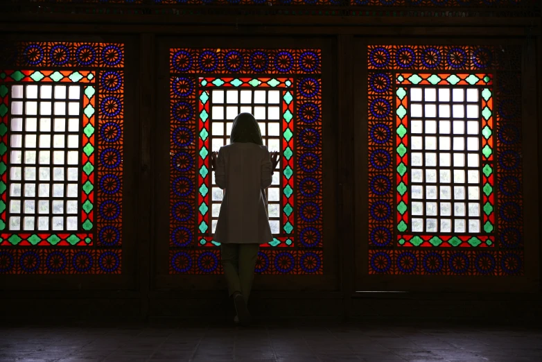 a person standing in front of stain glass windows