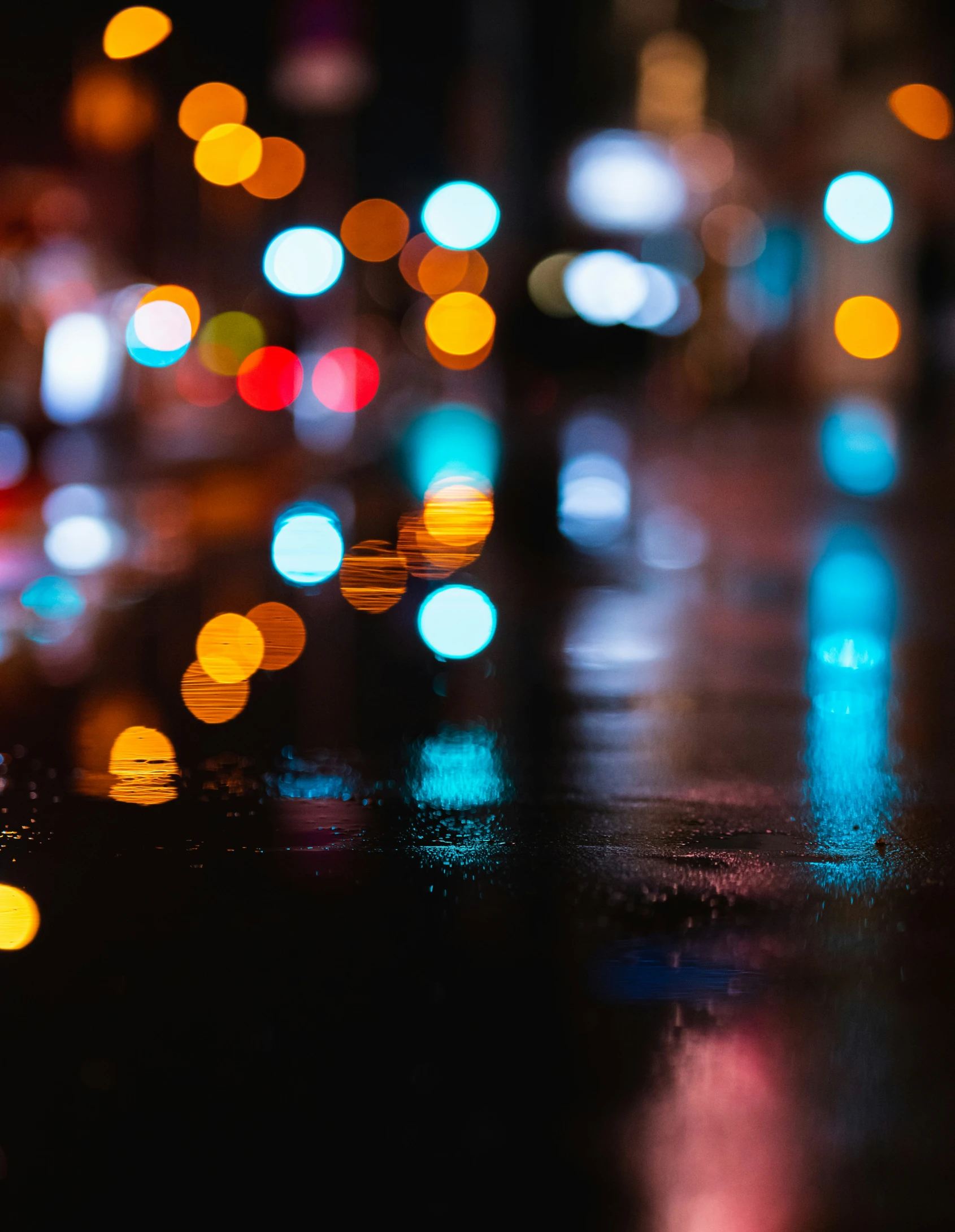 some traffic lights are reflected in the wet asphalt