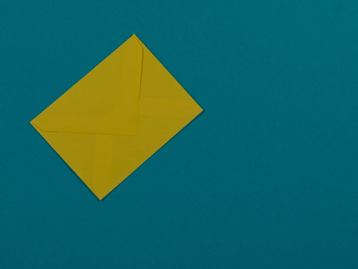 an orange square origami piece sits on blue paper