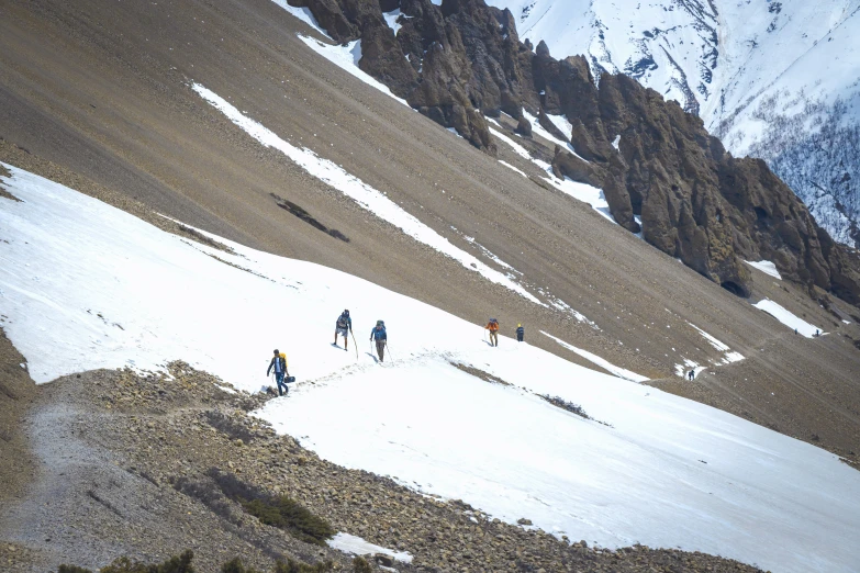 five people skiing up the side of a mountain