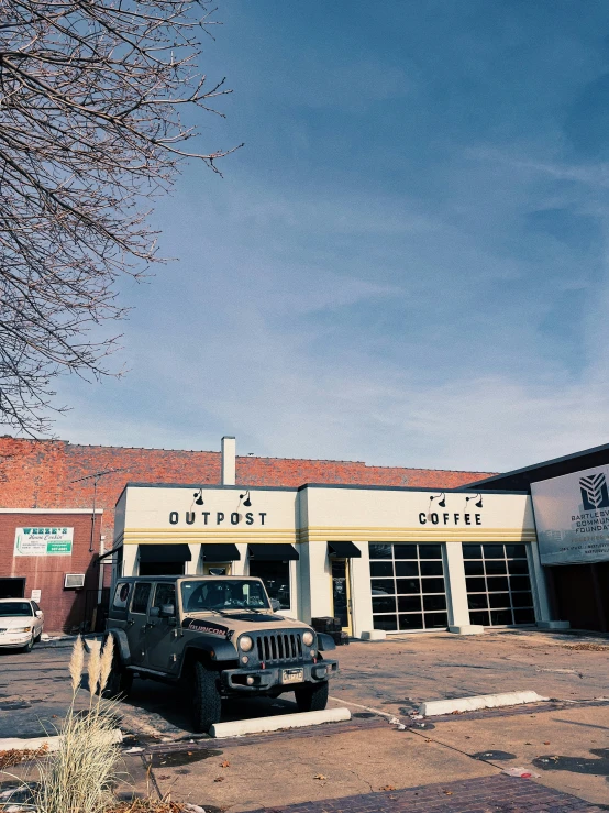 the front of an old fashioned business with a black jeep in front