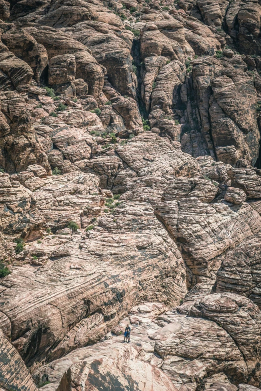 two people hiking on the rocks at the edge of a gorge