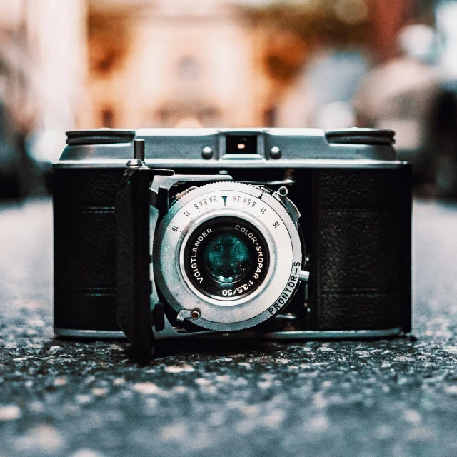 an old camera on a sidewalk on the ground