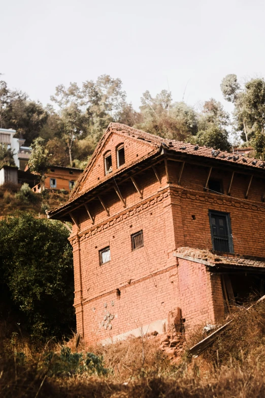 a brick building surrounded by grass and trees