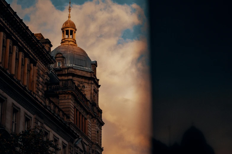 a building has a gold roof with a clock on top