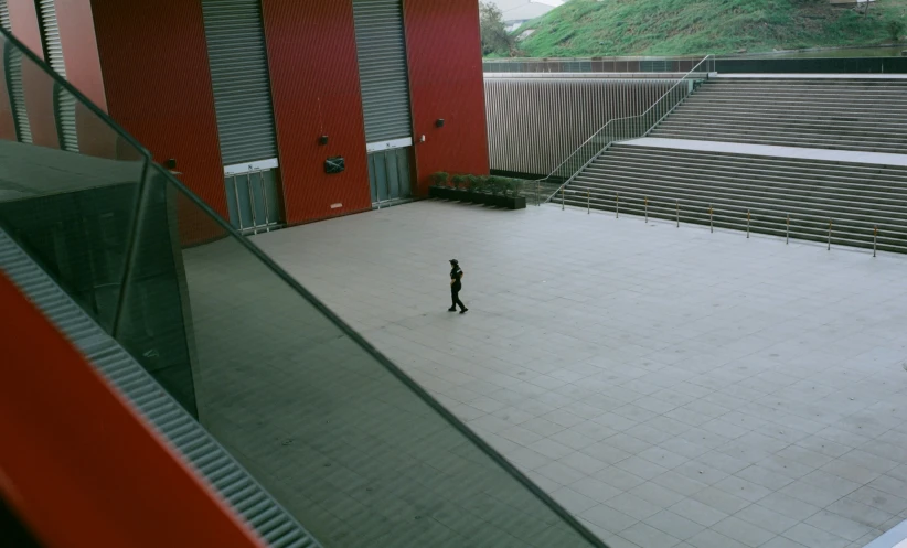 person walking through empty sports arena with steps