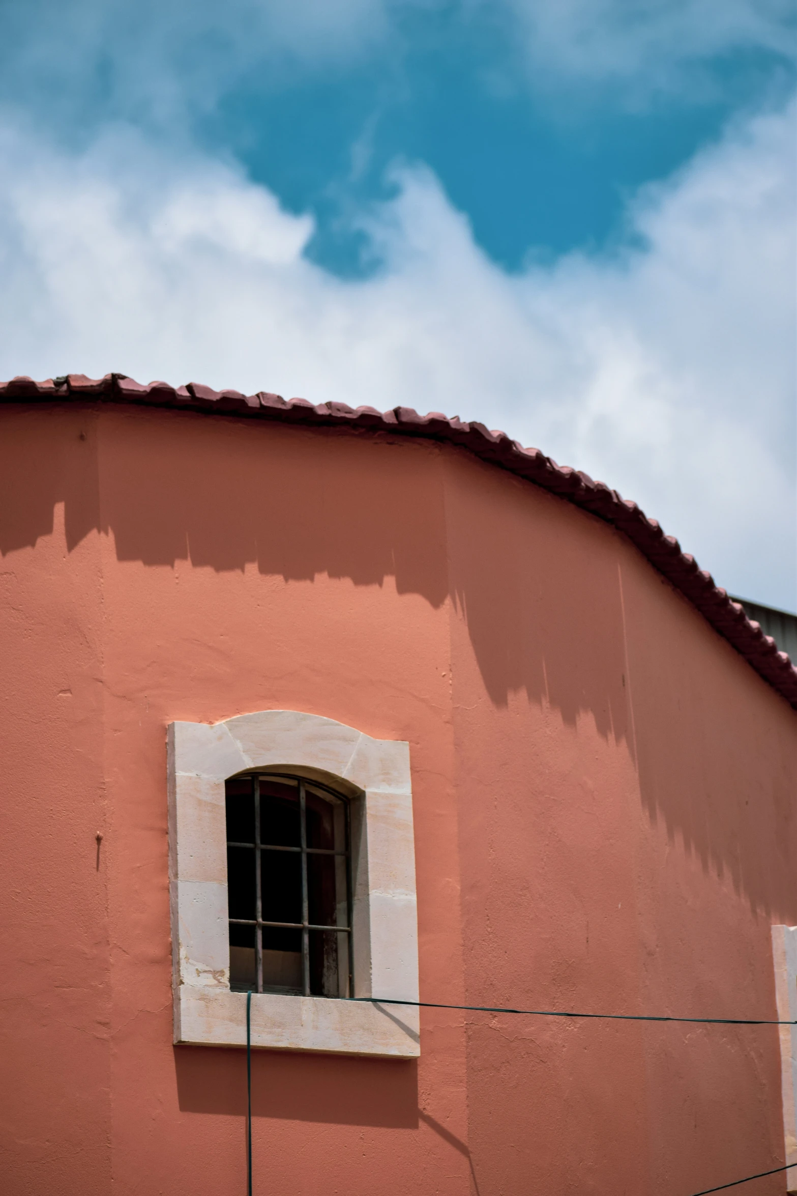 a window in the side of a pink building