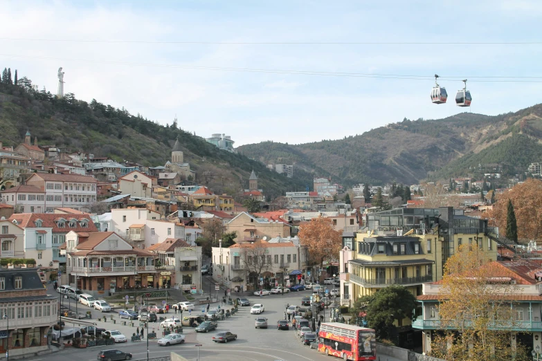 a town street filled with traffic surrounded by mountains