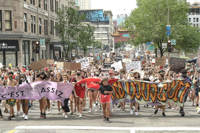 many people are walking down a street holding banners