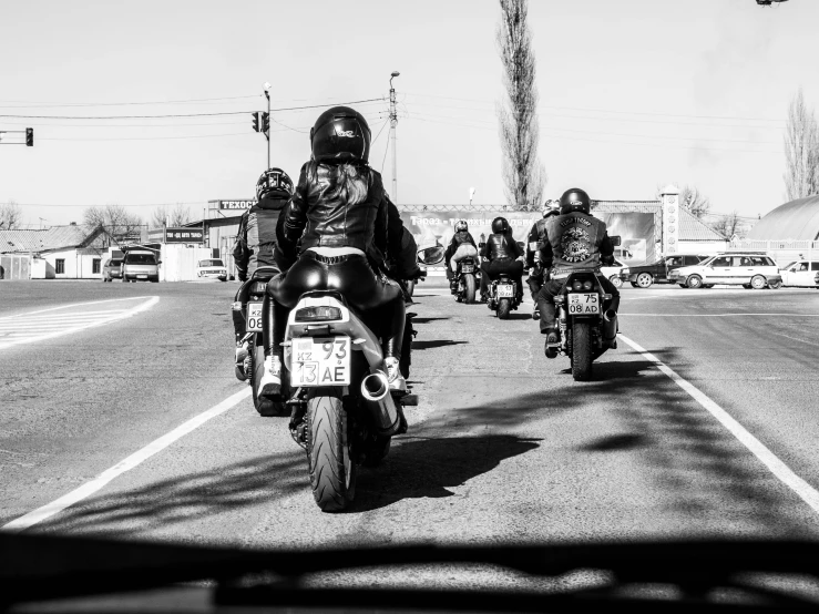 a group of people on motorcycles ride down the road