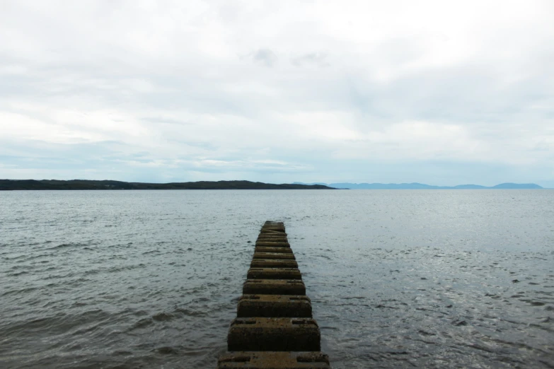 this is a long wooden pier on the edge of a lake