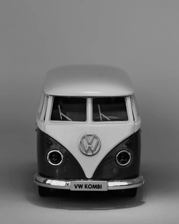a toy vw bus is standing on a grey background