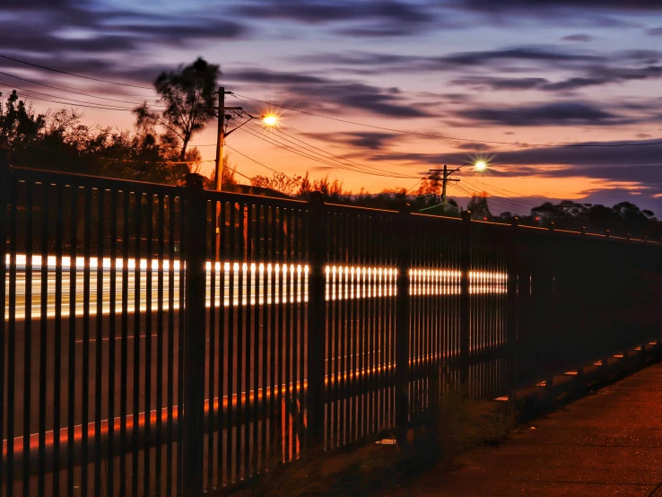 a long fence sitting on the side of a road