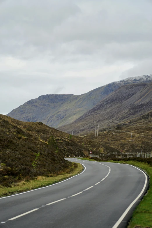 two people riding a bike down a curvy road