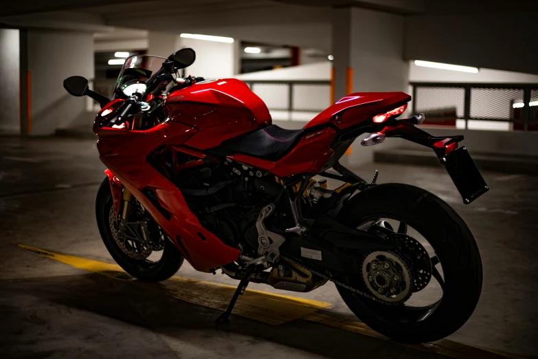 a red motor bike parked in a parking lot