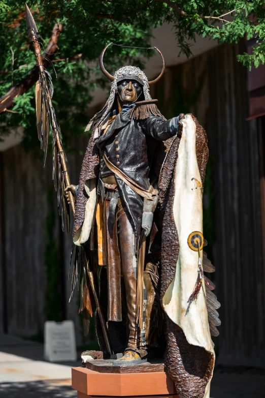 a statue of a male in costume with long horns