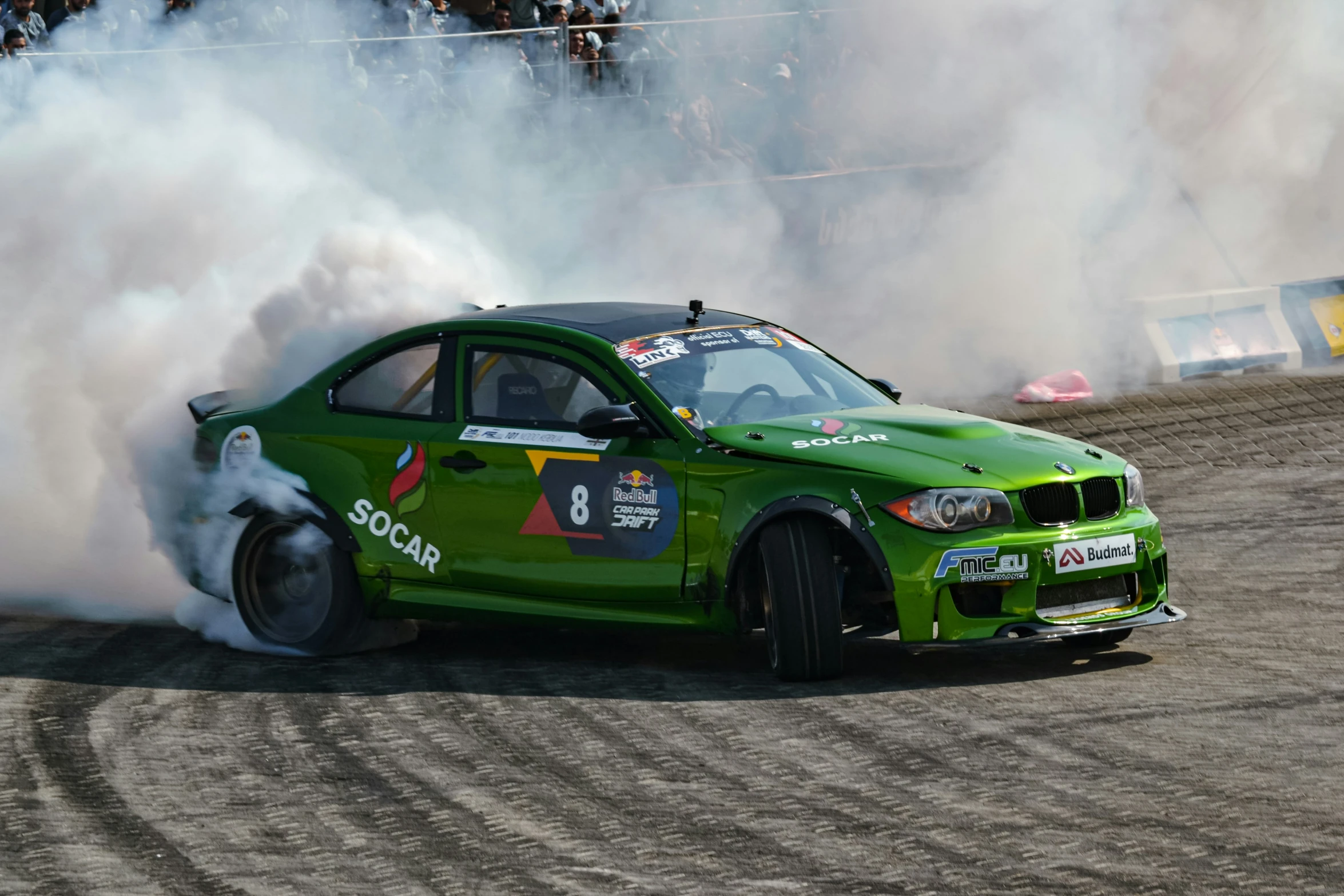 a green car with smoke pouring out of it