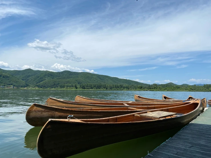 two wooden canoes lined up next to a pier