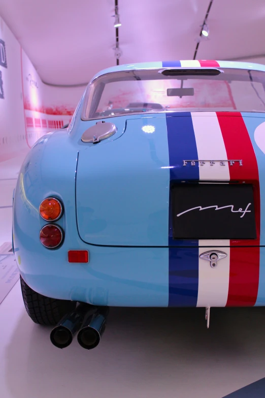 an old blue sports car sitting on a display