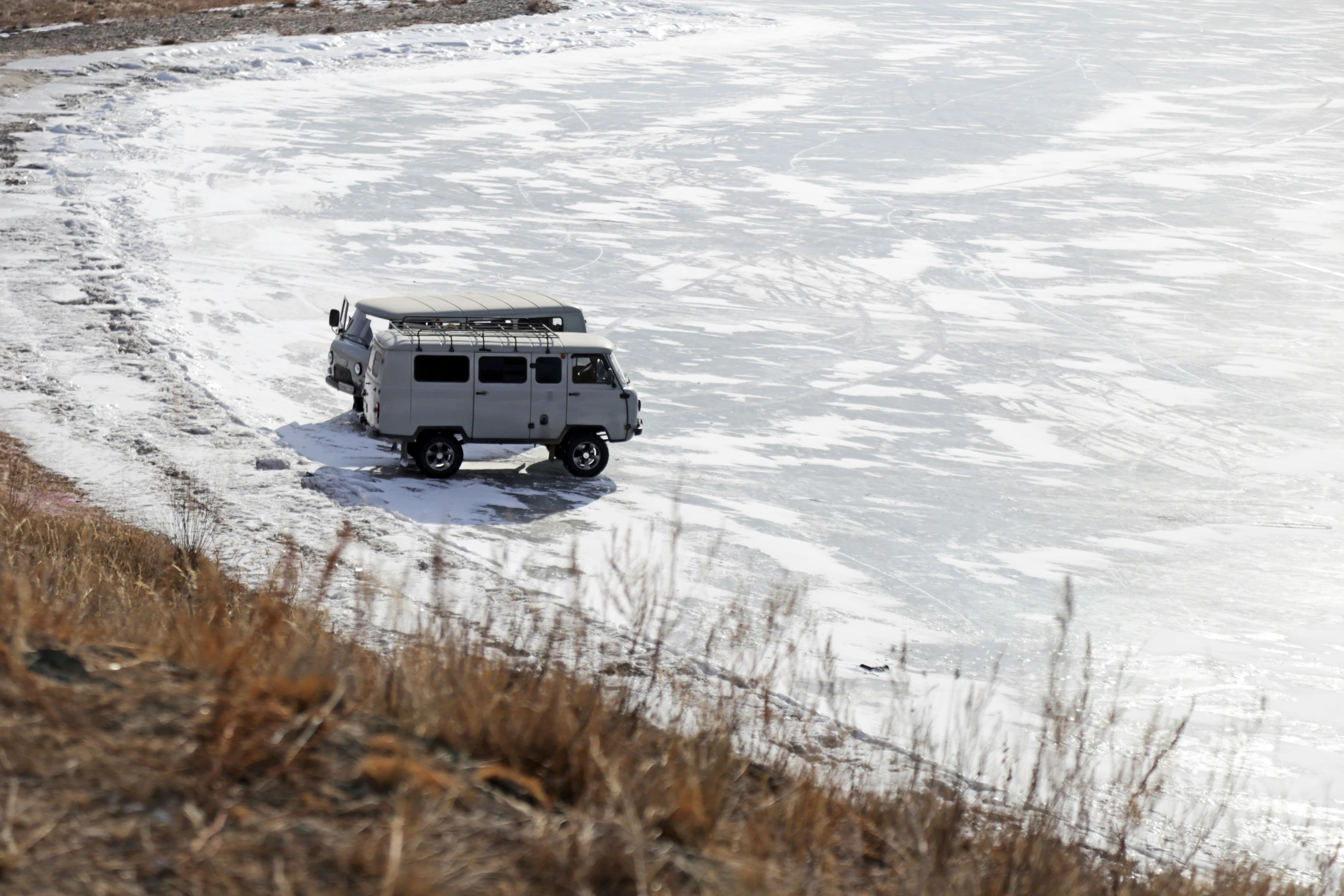 a vehicle driving down a snowy road with a roof tent on it