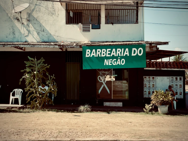a green sign that says, barberia do nego
