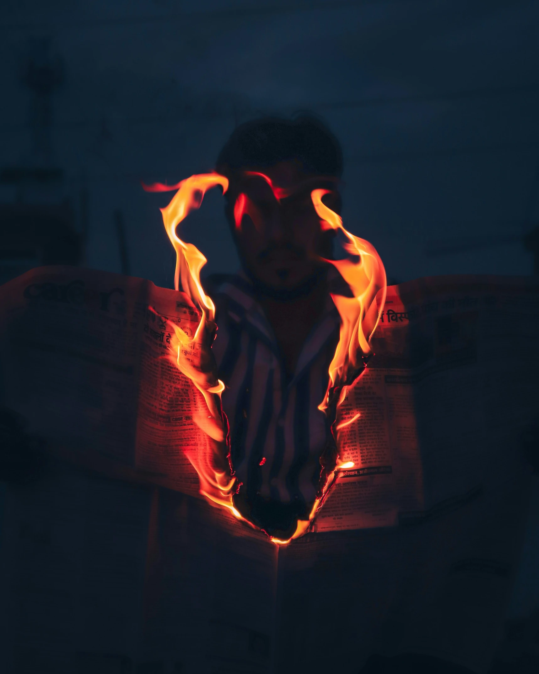 a man holding a surfboard in flames with it's reflection