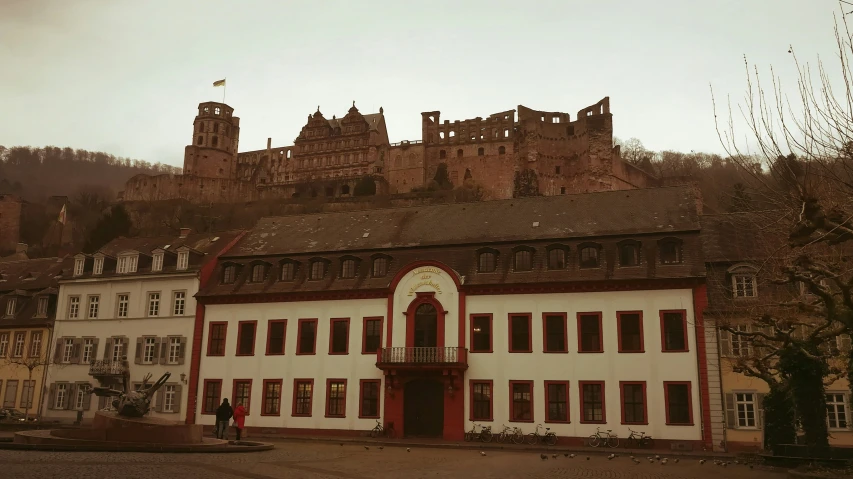 an old building with a castle in the background