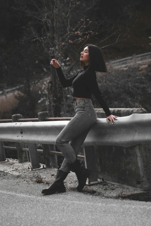 a woman leaning on a concrete railing while holding an umbrella