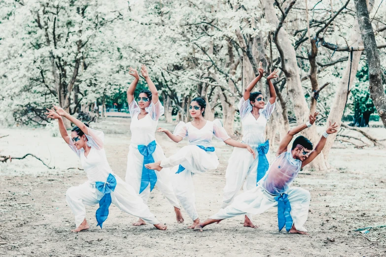 women wearing white dress dancing in front of trees