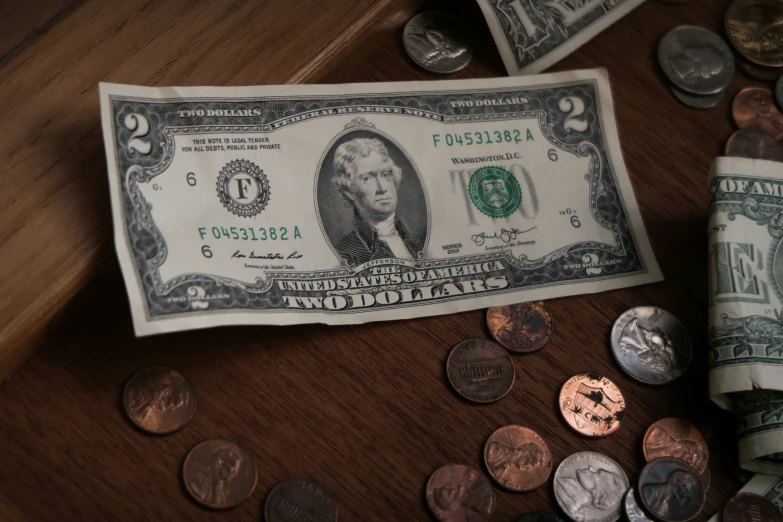 a dollar bill with quarters and a roll of paper money