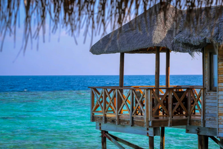 the view from a beach house with a tiki roof