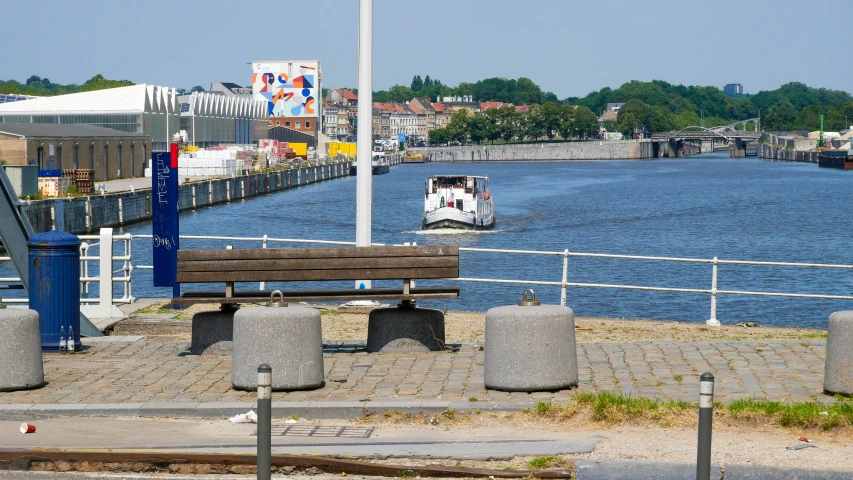 a boat in the middle of a river by a metal fence