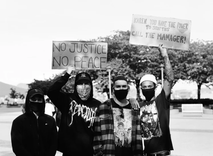 the protestors are wearing face masks and holding up their signs