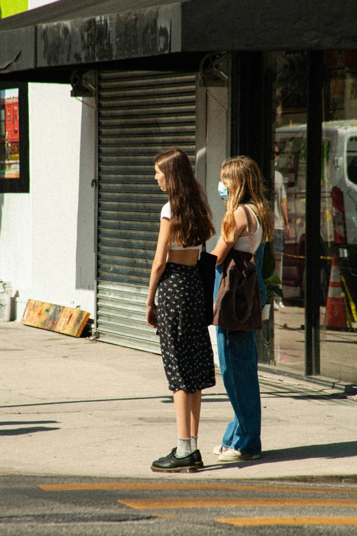 two s in dresses and face masks on the street