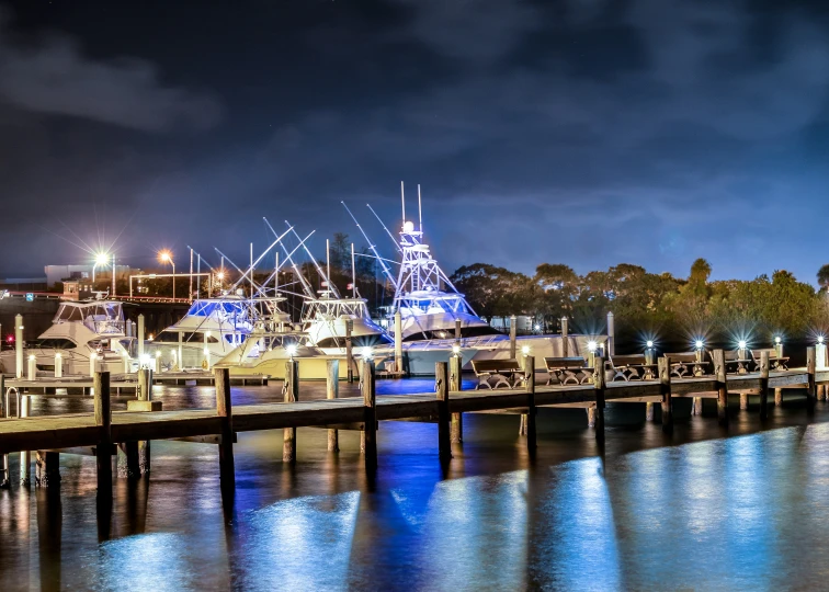 a dock with a lot of docked boats on it at night