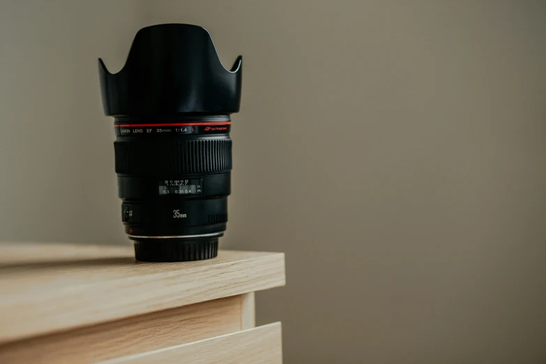 a camera lens is placed upon a wooden ledge